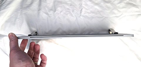The holder from the side, in a hand: thin and flat, with the two visor clips on top.