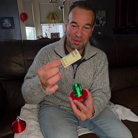 Enrique pulling the rolled cash out of the ornament.