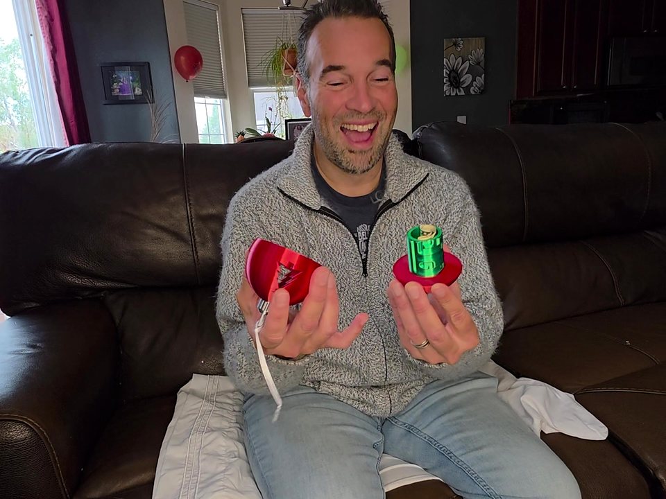Enrique laughing as the ornament opens and the rolled cash comes out.